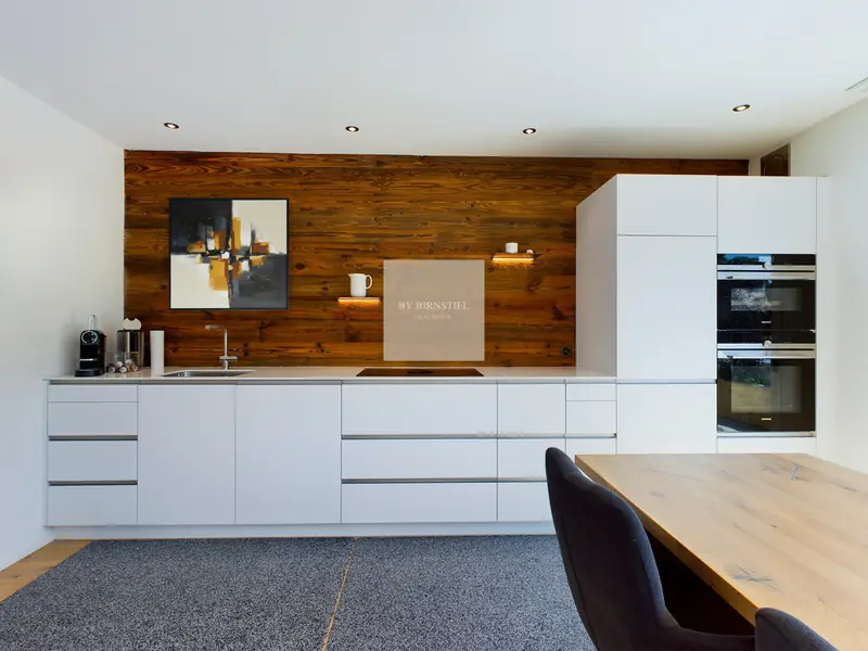 Modern kitchen with a reclaimed wood wall in the property sold in Menziken