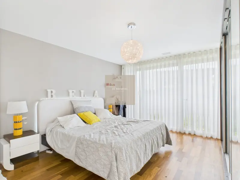 Bright bedroom with parquet floor and floor-to-ceiling windows