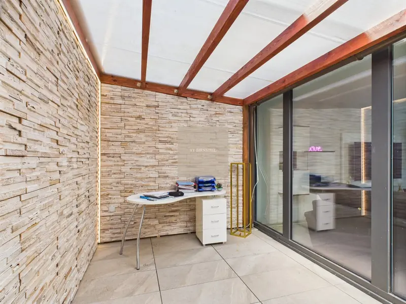 Covered conservatory with natural stone wall