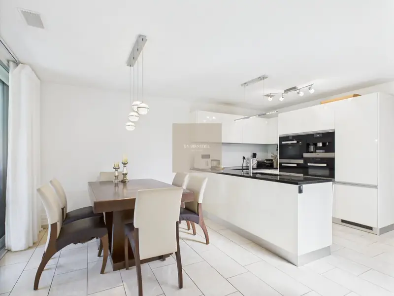 Bright living and dining area with kitchen island in the terraced house in Oberrohrdorf
