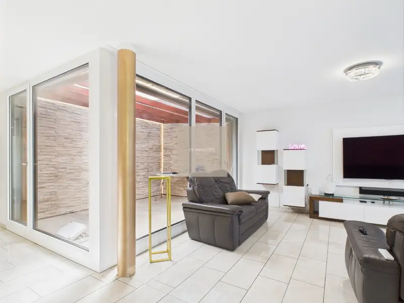 Living room with large glass frontage onto the conservatory